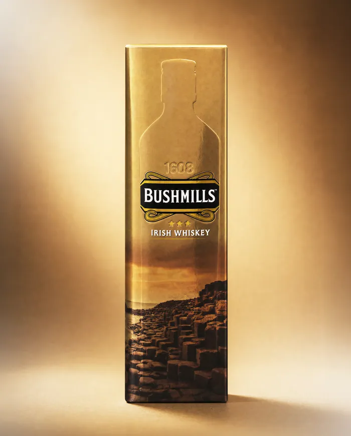 Bushmills Irish Whiskey carton in metallic gold with an embossed bottle outline